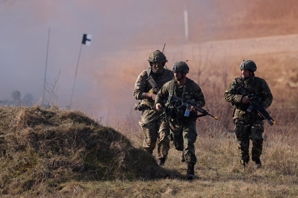 British soldiers storm an enemy position in a simulated attack during Nato drills in Poland