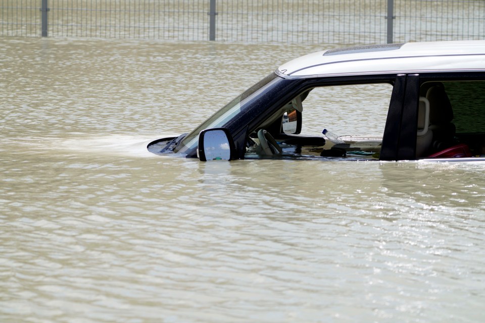 Debris floats through an SUV abandoned in floodwater