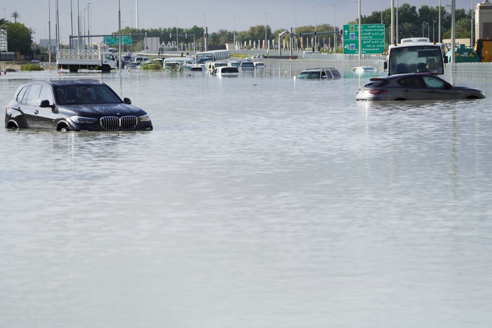 Vehicles sit abandoned in floodwater covering a major road in Dubai on Wednesday