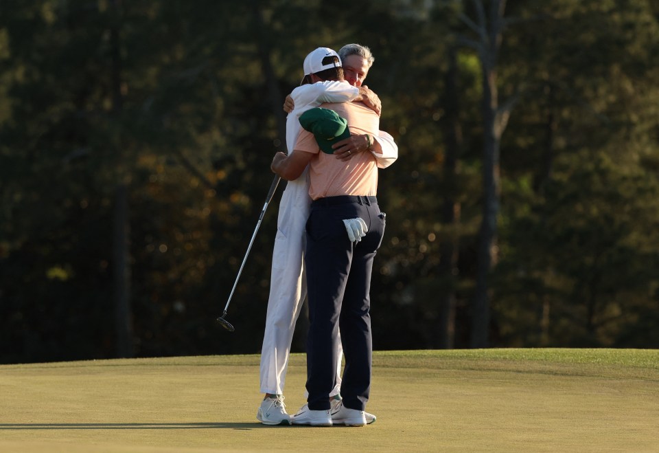 Caddie Ted Scott celebrates with Scheffler on the 18th