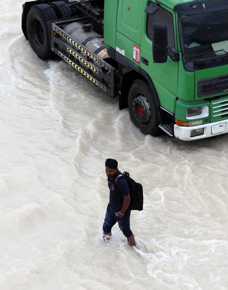 A man wades through a flooded street in Dubai on Tuesday