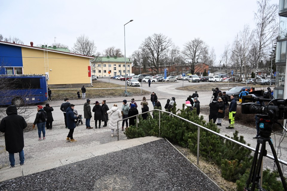 Crowds of concerned parents gather outside the school