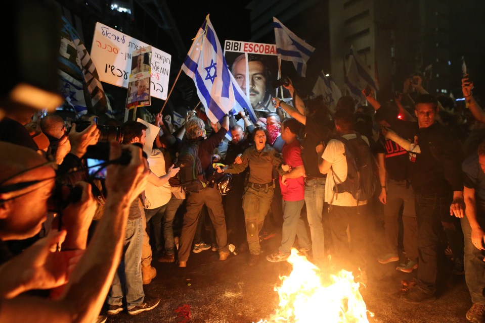 Demonstrators light a fire at Kaplan Street as thousands of Israeli citizens stage a demonstration demanding Benjamin Netanyahu's resignation