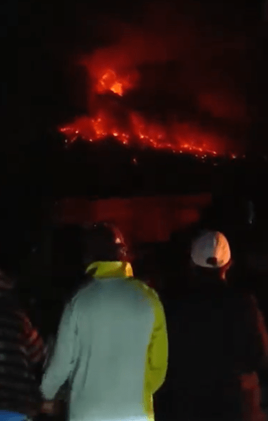 Crowds watch as lava spews from the volcano