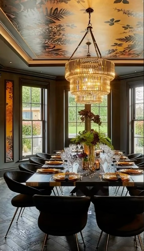 Her dining room features a black and gold look along with leopard print wallpaper and a huge chandelier to fill the high ceiling