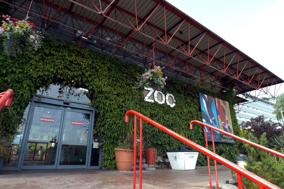 the entrance to the zoo has a red sign that says entrance