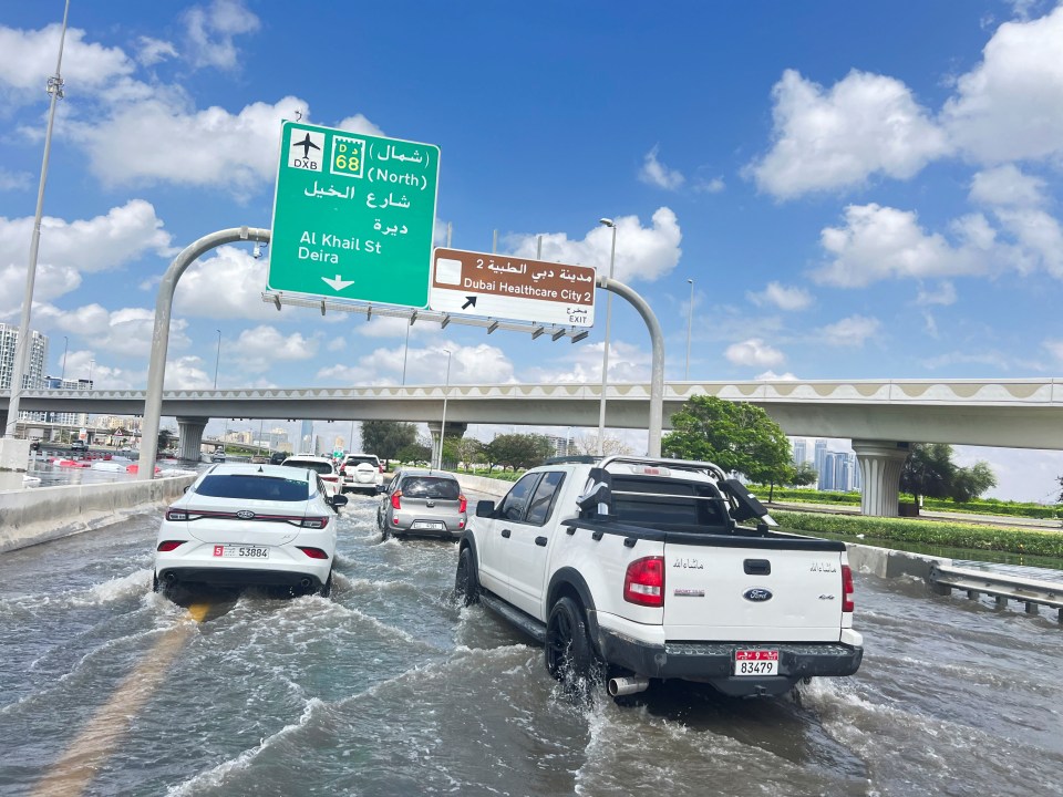 Cars drive through a flooded road on Wednesday