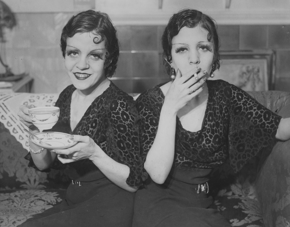 Singers and dancers Violet, left, and Daisy, right, pose on a couch in London