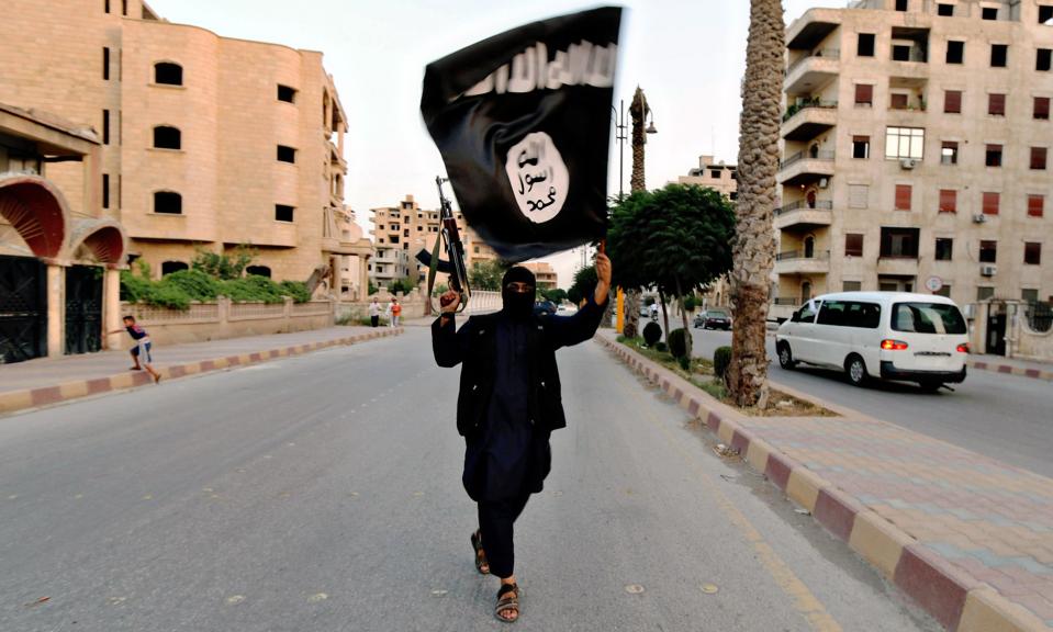 EFTM24 Islamic State of Iraq and the Levant fighter waves a Black flag during a military parade in Raqqa province in Syria June 29, 2014 shown in propaganda photos released by the militants.