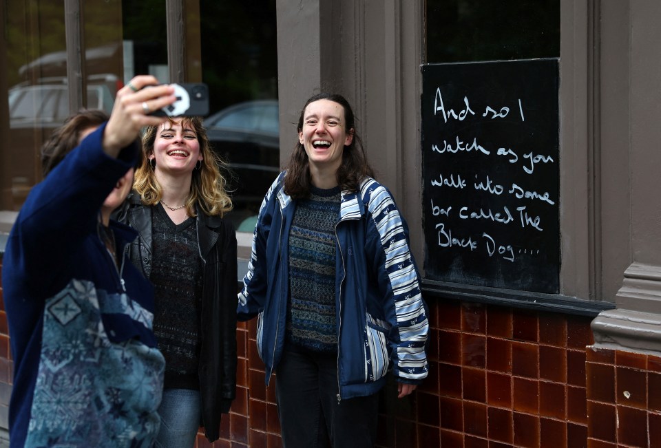 Swifties pose for a selfie outside The Black Dog pub in London