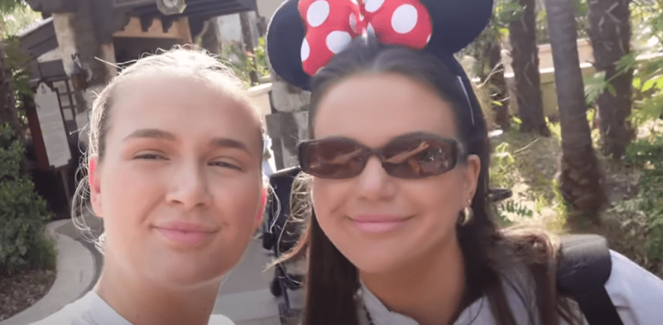 two women wearing minnie mouse ears pose for a picture