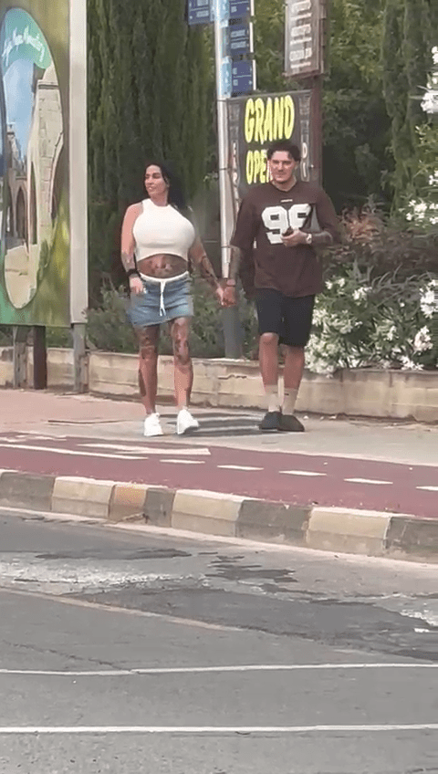 Katie Price and JJ Slater walking hand-in-hand down a street.