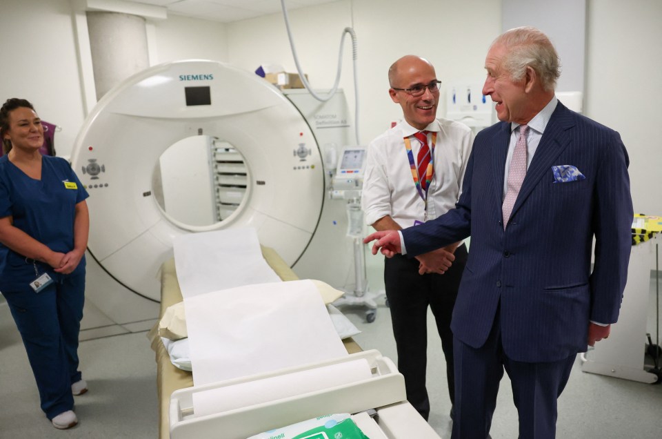 The King laughs with Cancer Research UK’s Chief Clinician, Charlie Swanton next to a CT scanner