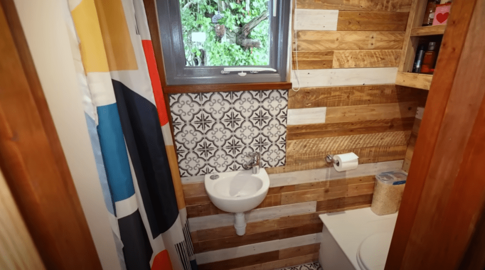 The bathroom has a full-sized shower and a compost toilet