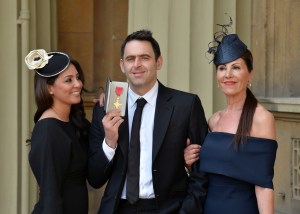  Ronnie posing with his partner Laila and mum Maria after receiving his OBE in May 2016