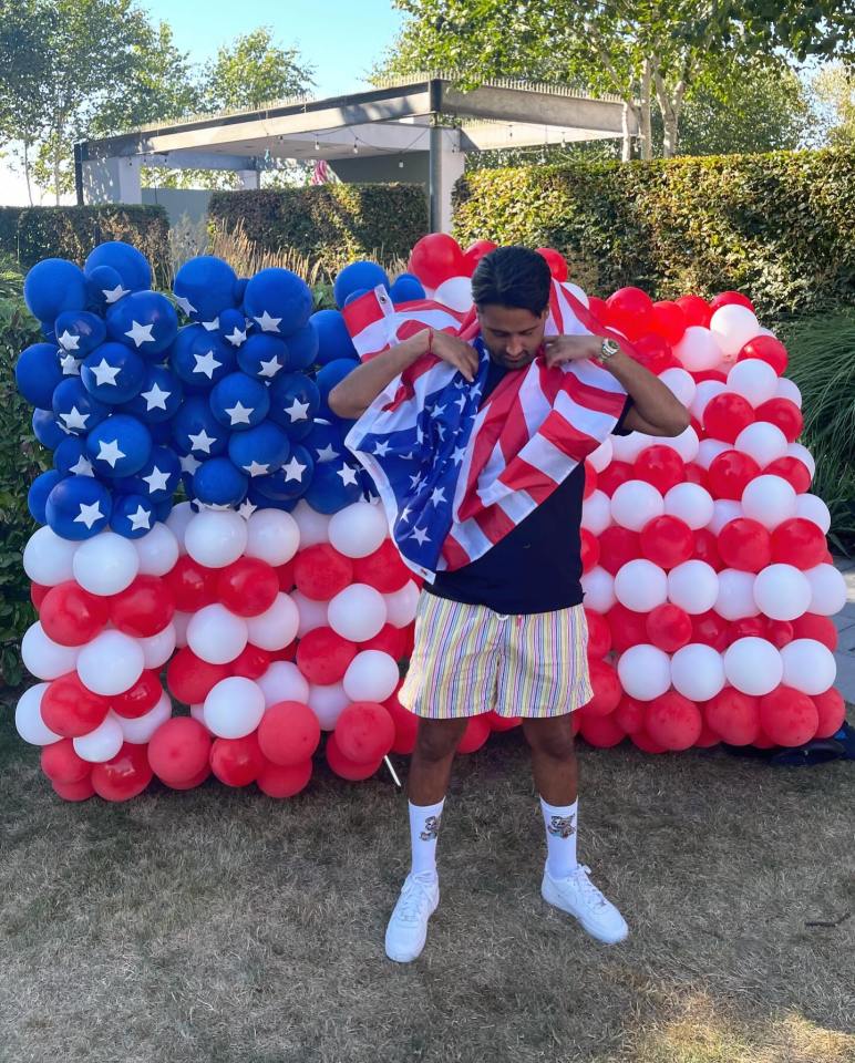 The reality star, 33, appeared to struggle putting the flag around his neck for the celebratory images