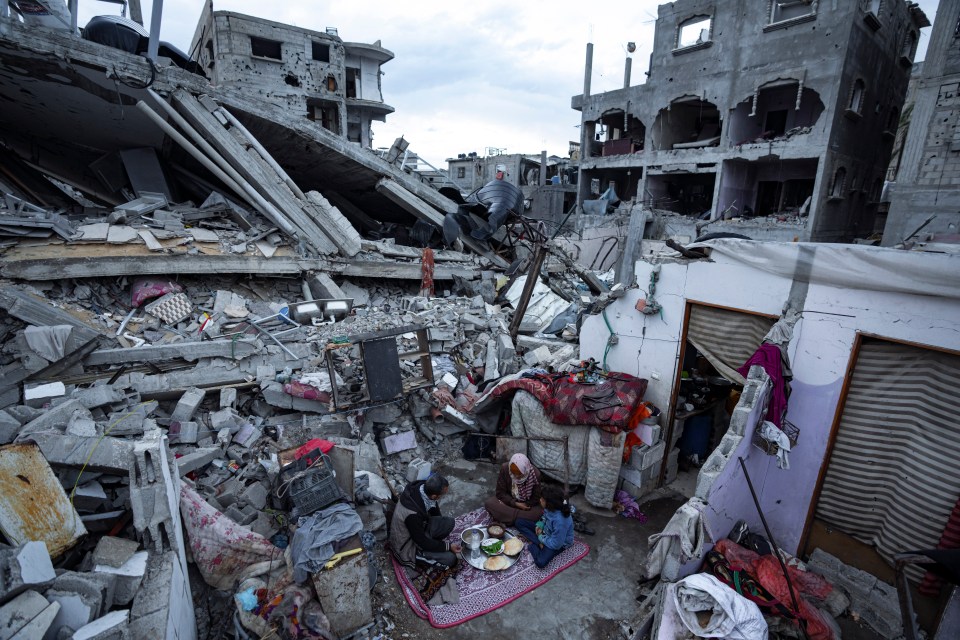 A family outside their destroyed home in Rafah