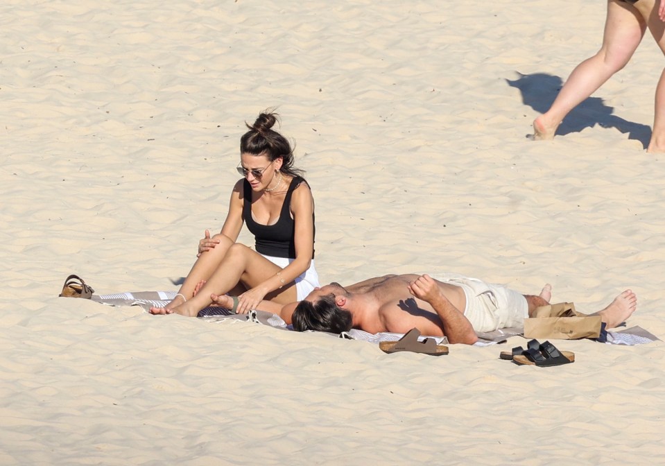 Michelle wore a black vest top along with white shorts to keep cool while shirtless Mark opted for cream swimming shorts