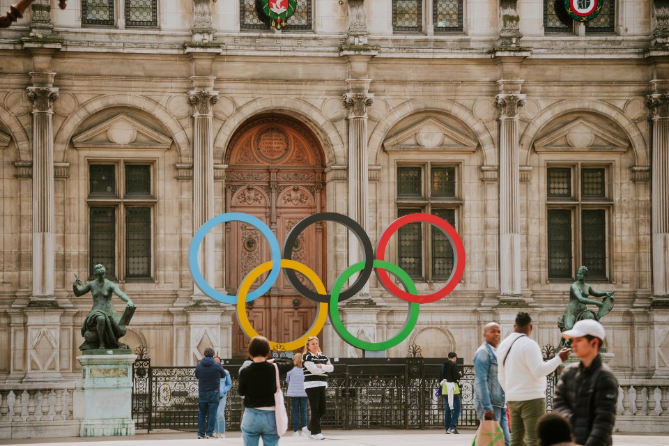 Paris, France - May 22, 2023: Olympic rings in front of the Hôtel de Ville in Spring 2023. The Hôtel de Ville is the city hall of Paris, France, standing on the Place de l'Hôtel-de-Ville  Esplanade de la Libération in the 4th arrondissement.<br />
The 2024 Summer Olympics (French: Jeux olympiques d'été de 2024), officially the Games of the XXXIII Olympiad (French: Jeux de la XXXIIIe Olympiade) and commonly known as Paris 2024, is an upcoming international multi-sport event that is scheduled to take place from 26 July to 11 August 2024. The Hôtel de Ville and its eponymous square will host events in the very centre of Frances capital during the Paris 2024 Olympic Games.