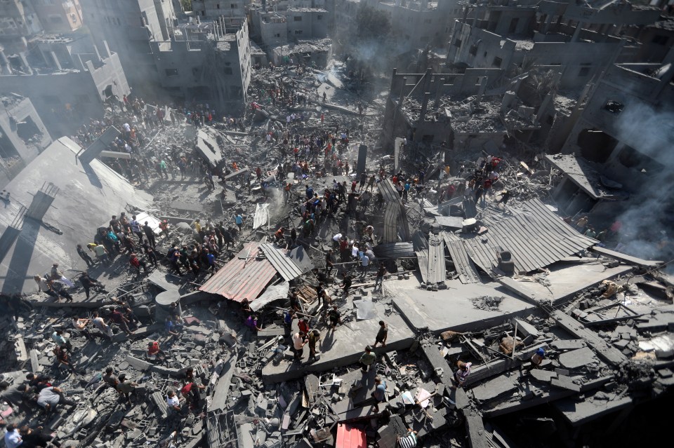 Palestinians inspect the rubble of destroyed buildings following Israeli airstrikes on the town of Khan Younis