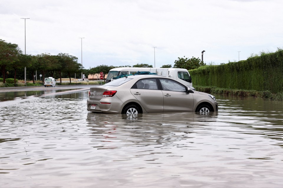 Parked cars stand in flood water following heavy rain on Tuesday