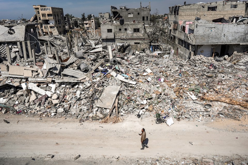 A man walks past the rubble in the blitzed Gaza city