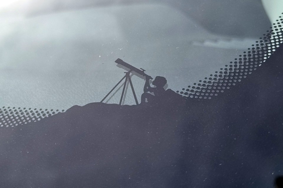 A boy points a telescope toward the heavens