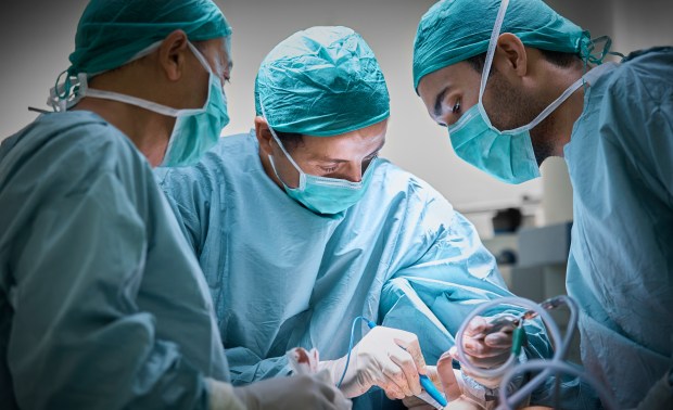 a group of surgeons are performing surgery on a patient