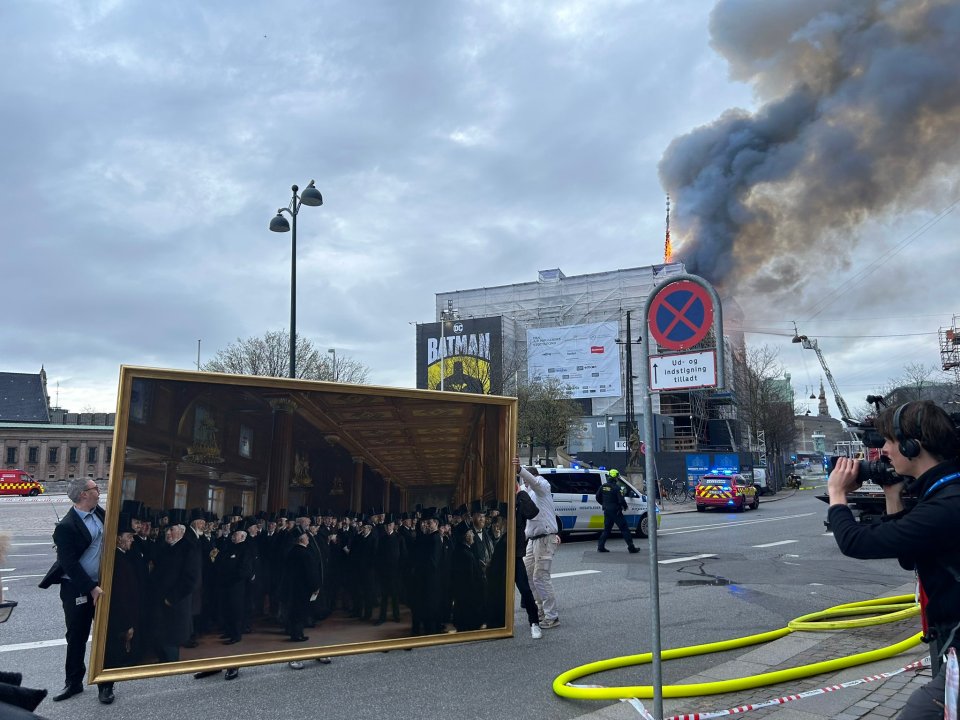 Locals appear to be rescuing a priceless paintings from the roaring  flames