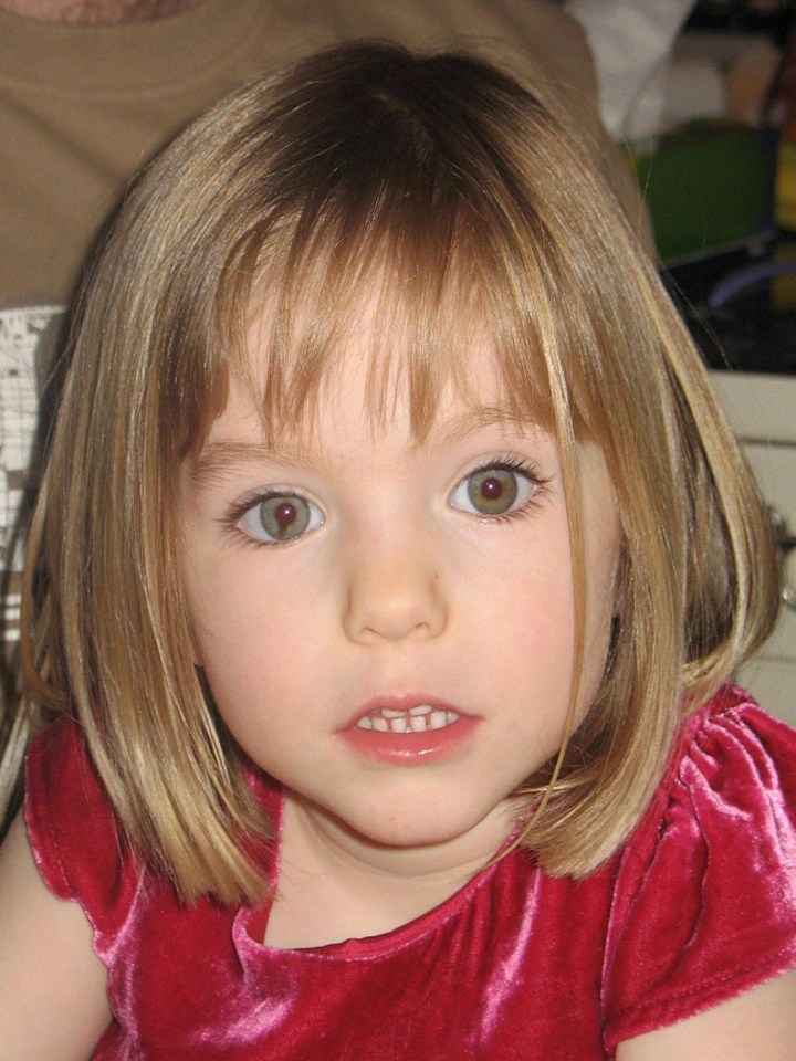 a little girl wearing a red velvet dress looks at the camera