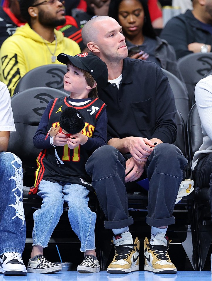 Actor Nicholas Hoult looks on with his son during the third quarter between the Atlanta Hawks and the Milwaukee Bucks at State Farm Arena on March 30, 2024 in Atlanta, Georgia