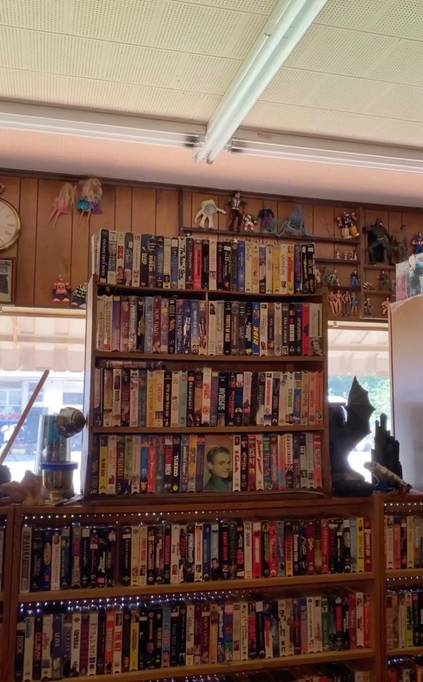 Some shelves are decorated with figurines of comic characters like Batman