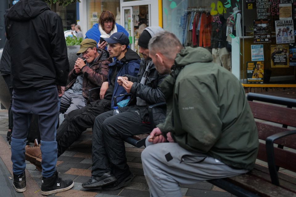 A group of men sat smoking in the city centre