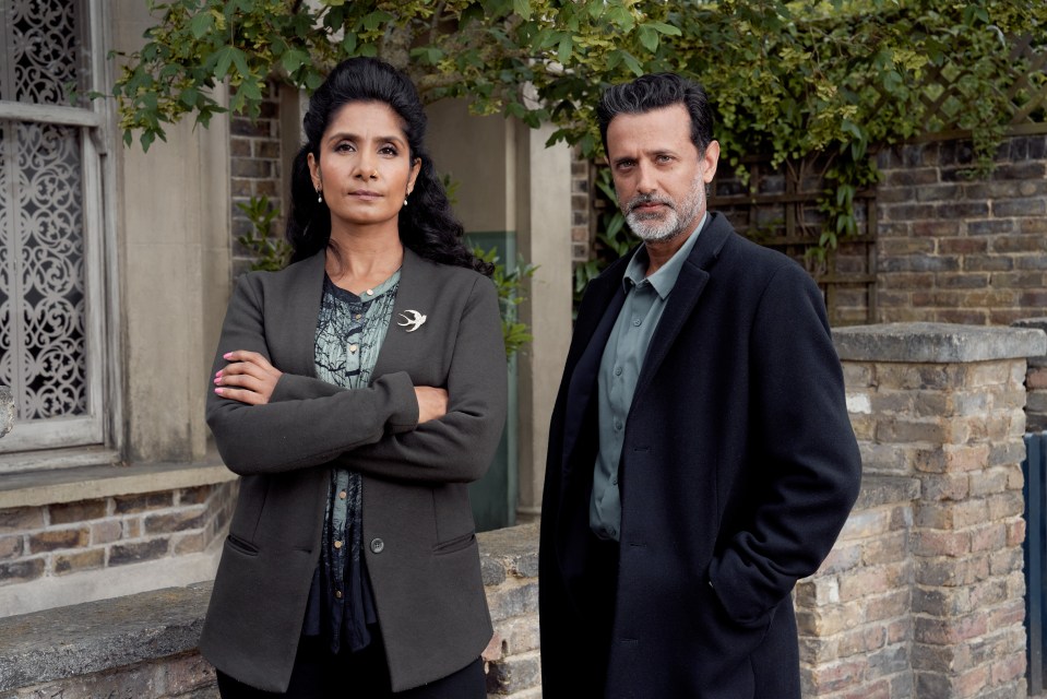 a man and a woman standing next to each other with their arms crossed