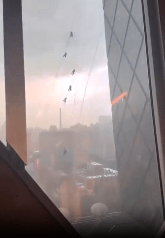 Terrified onlookers captured the moment window cleaners were thrown around by strong winds