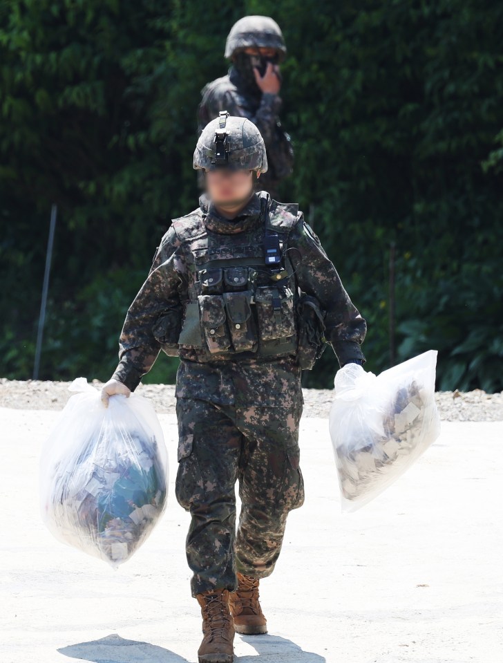 South Korean soldiers collect trash from the balloons