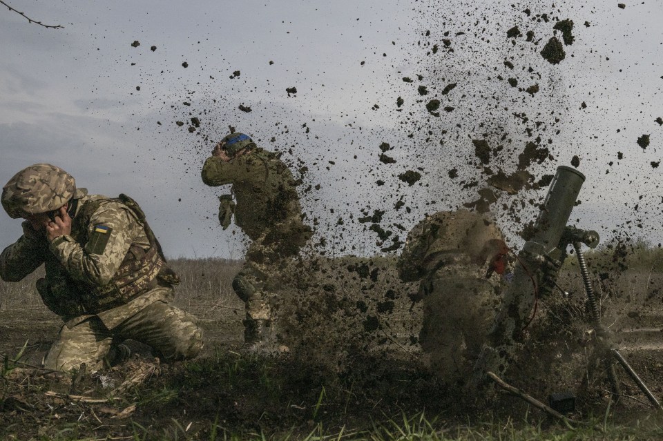 a group of soldiers are kneeling in the mud