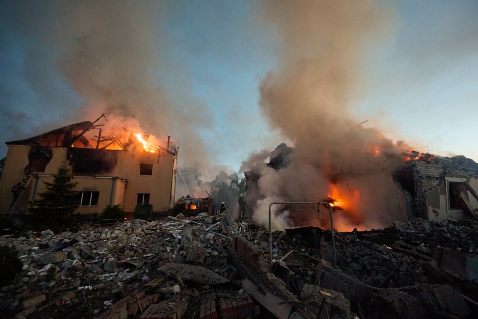 Ukrainian rescuers work to extinguish a fire at the site of a missile strike on private buildings in Kharkiv, northeastern Ukraine