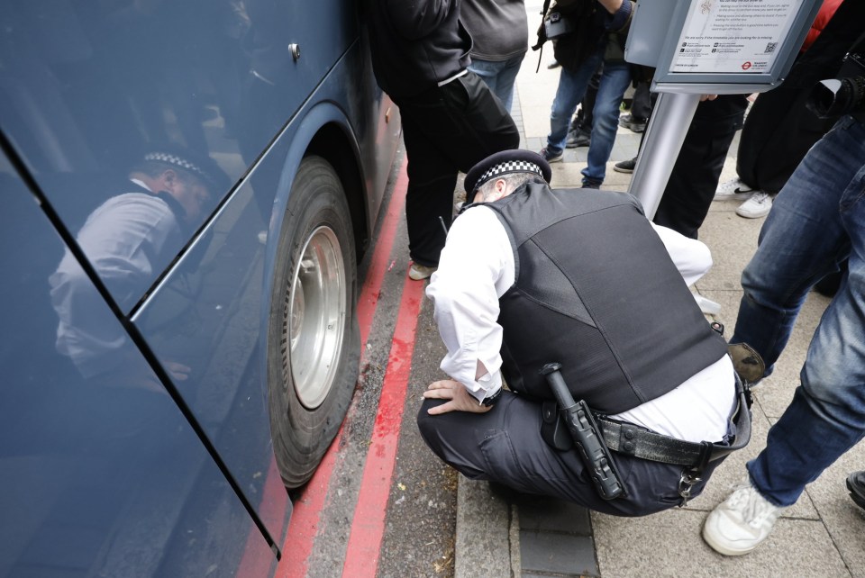 A police officer inspects the slashed tyres