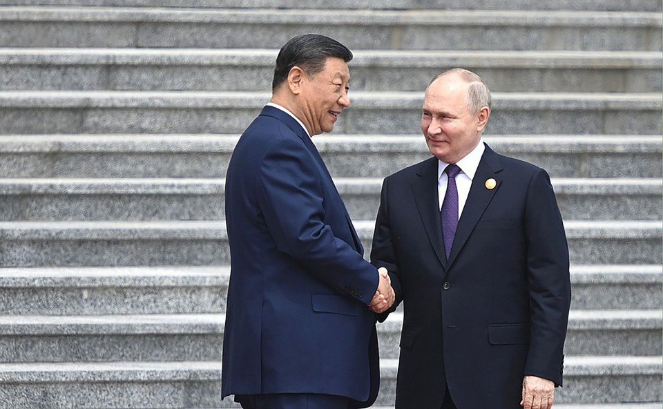 Vladimir Putin and Xi Jinping shake hands as they meet for a summit