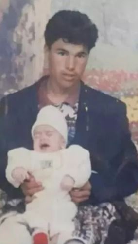 Omar pictured holding a baby before his 1998 disappearance