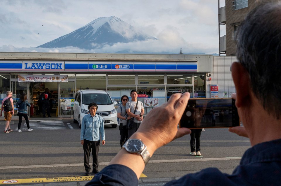 Tourists often gather in the road to grab the perfect picture in front of Mount Fuji