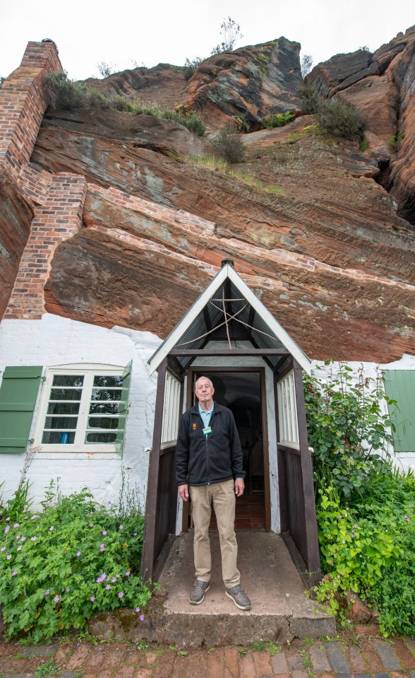 The homes are nestled beneath a sandstone cliff