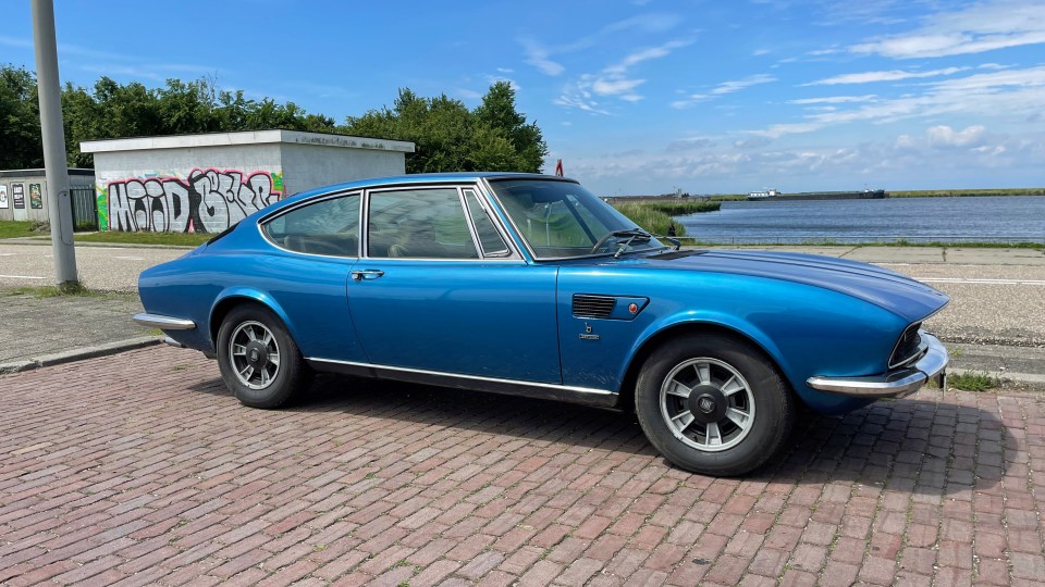 Blue Fiat Dino Coupe 2400 parked in a lot.