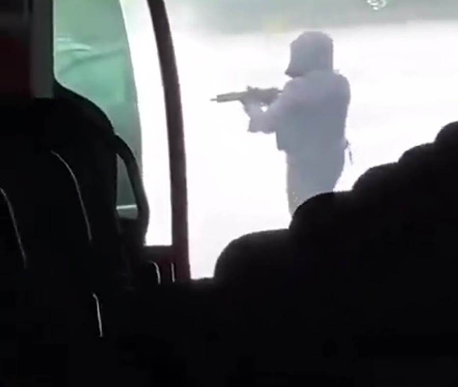 One of the shooters brandishes a huge rifle at the scene of the attack