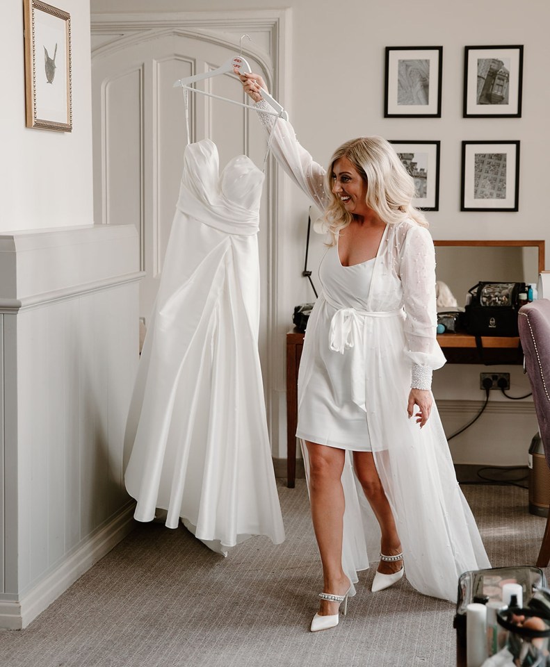 PIC FROM Kennedy News/Nicola Drummond Photography (PICTURED: KIRSTY HARVEY, 33, WITH HER DRESS ON HER WEDDING DAY) Defiant newlyweds defended splashing more than £40,000 on their wedding after being branded 'insane' by trolls - claiming they 'worked hard' and sacrificed holidays for their dream day.High school sweethearts Kirsty and Sam Harvey, both 33, tied the knot on last June after being together since they were 16.The couple booked their £15,470 venue, De Vere Tortworth Court in Wotton-under-Edge, Gloucestershire, back in 2021 paying for it in four instalments over two years.DISCLAIMER: While Kennedy News and Media uses its best endeavours to establish the copyright and authenticity of all pictures supplied, it accepts no liability for any damage, loss or legal action caused by the use of images supplied and the publication of images is solely at your discretion. SEE KENNEDY NEWS COPY - 0161 697 4266..