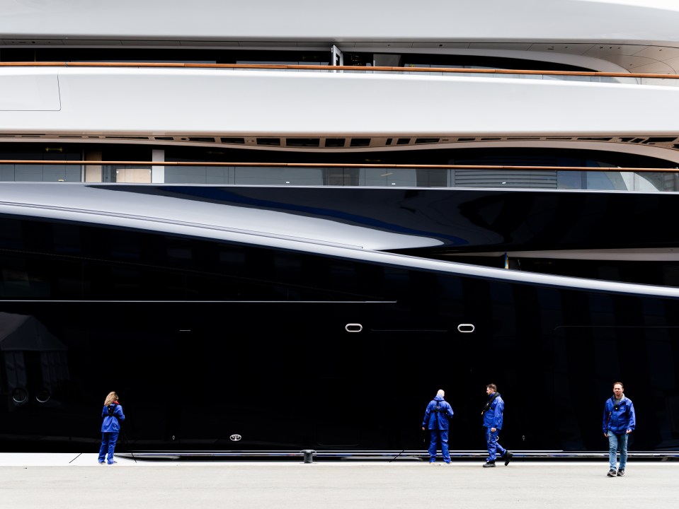 Workers stood alongside the yacht demonstrate its sheer size