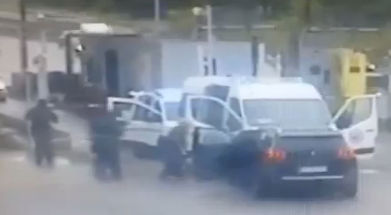 Someone who appears to be the prisoner (centre) jumps from a vehicle