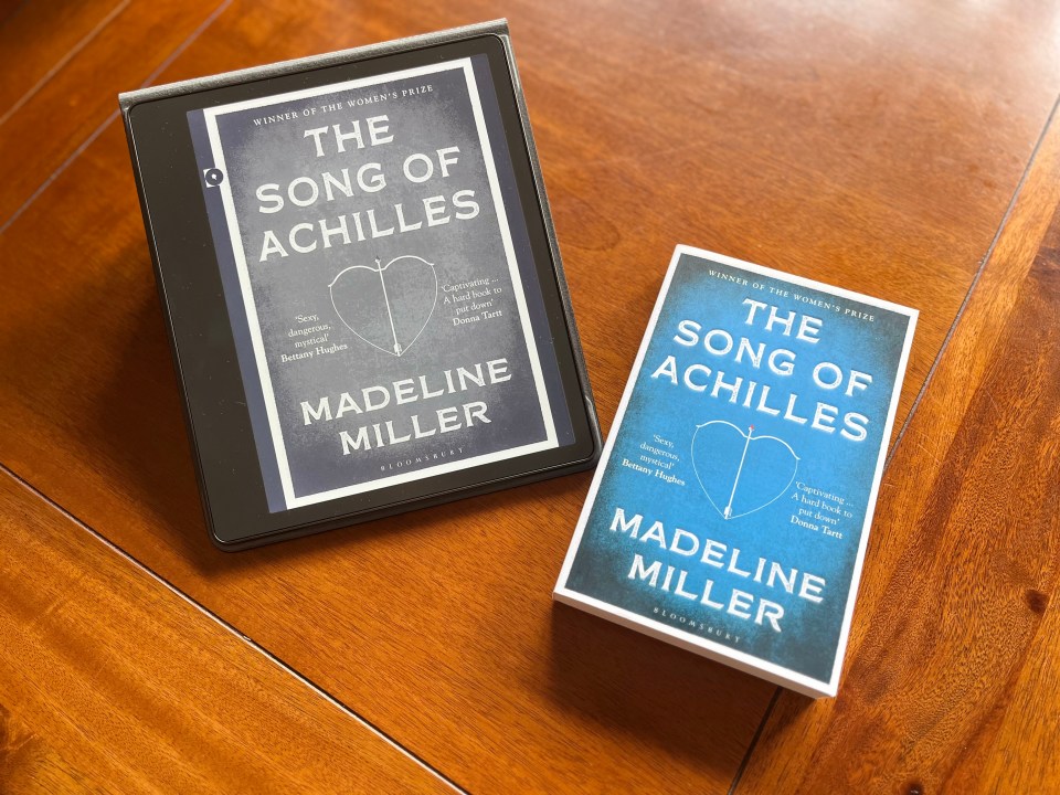 E-reader and paperback of Madeline Miller's "The Song of Achilles."