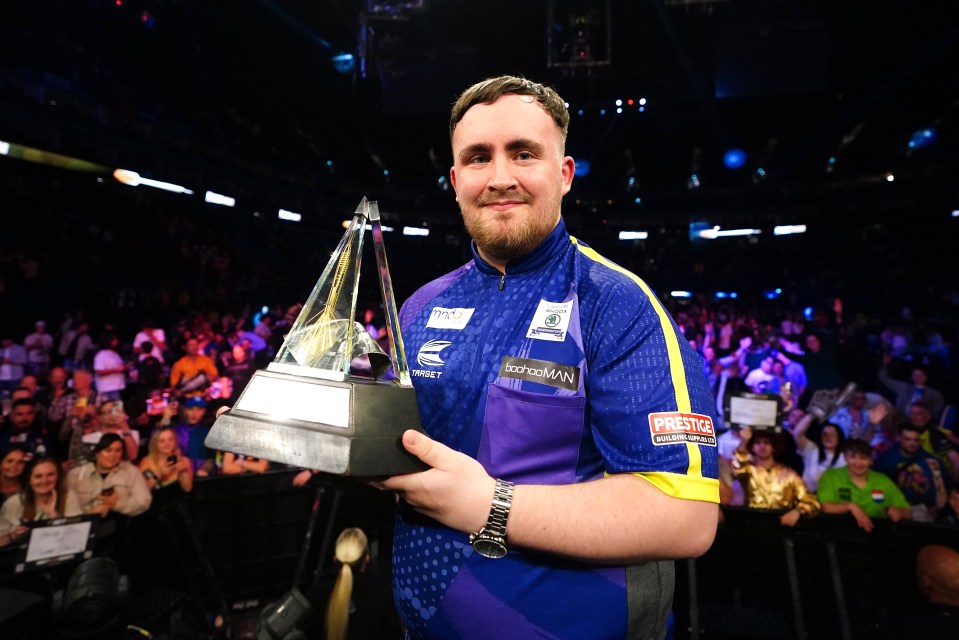 Luke Littler celebrates with the trophy after victory over Luke Humphries